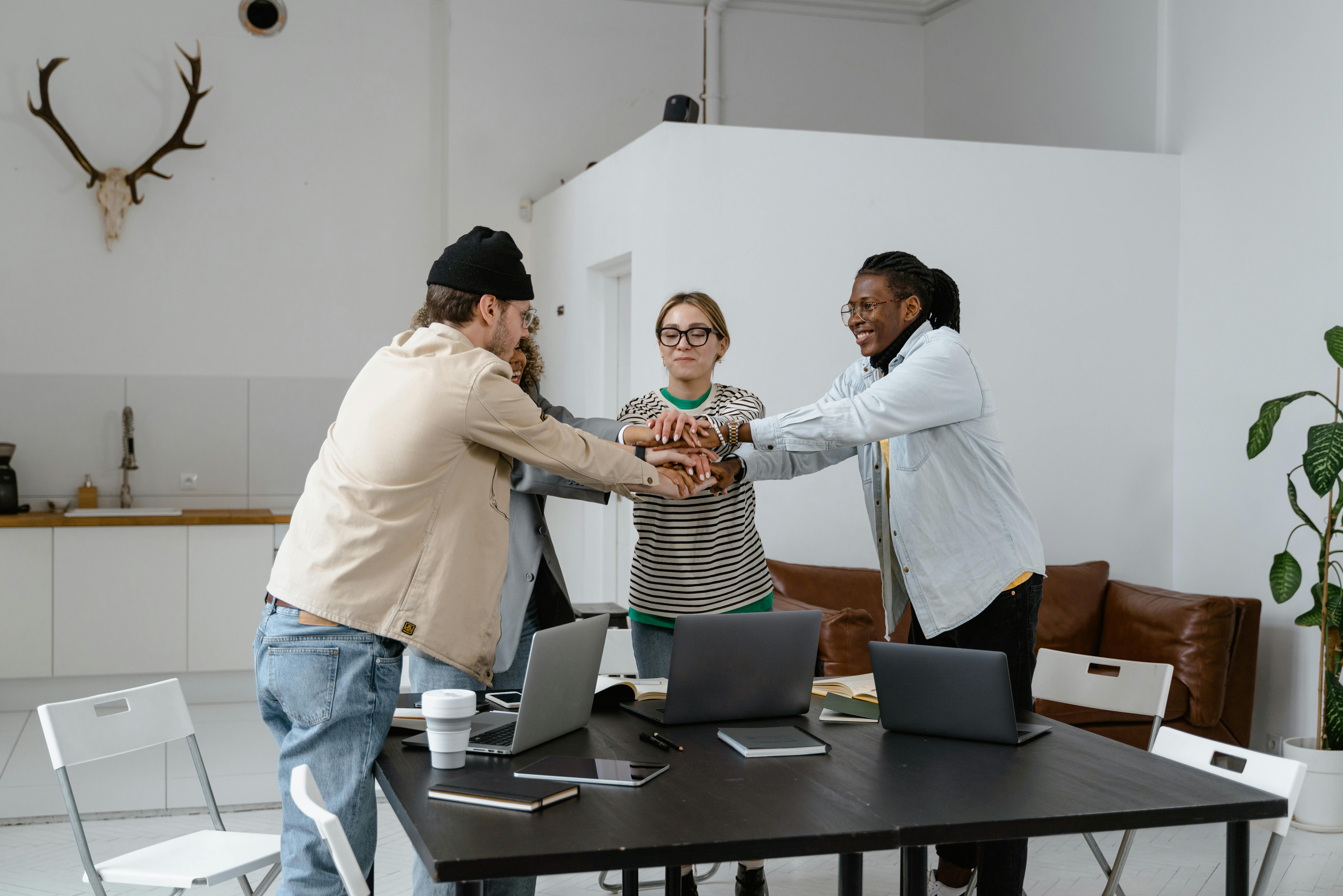 Team stacking hands together in an office